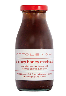 Bottle of Ottolenghi smoky honey marinade with a red cap on a white background