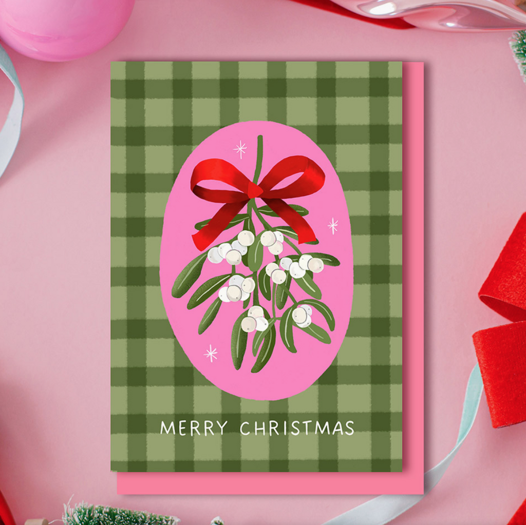 Christmas card with mistletoe design on a green and pink checkered background