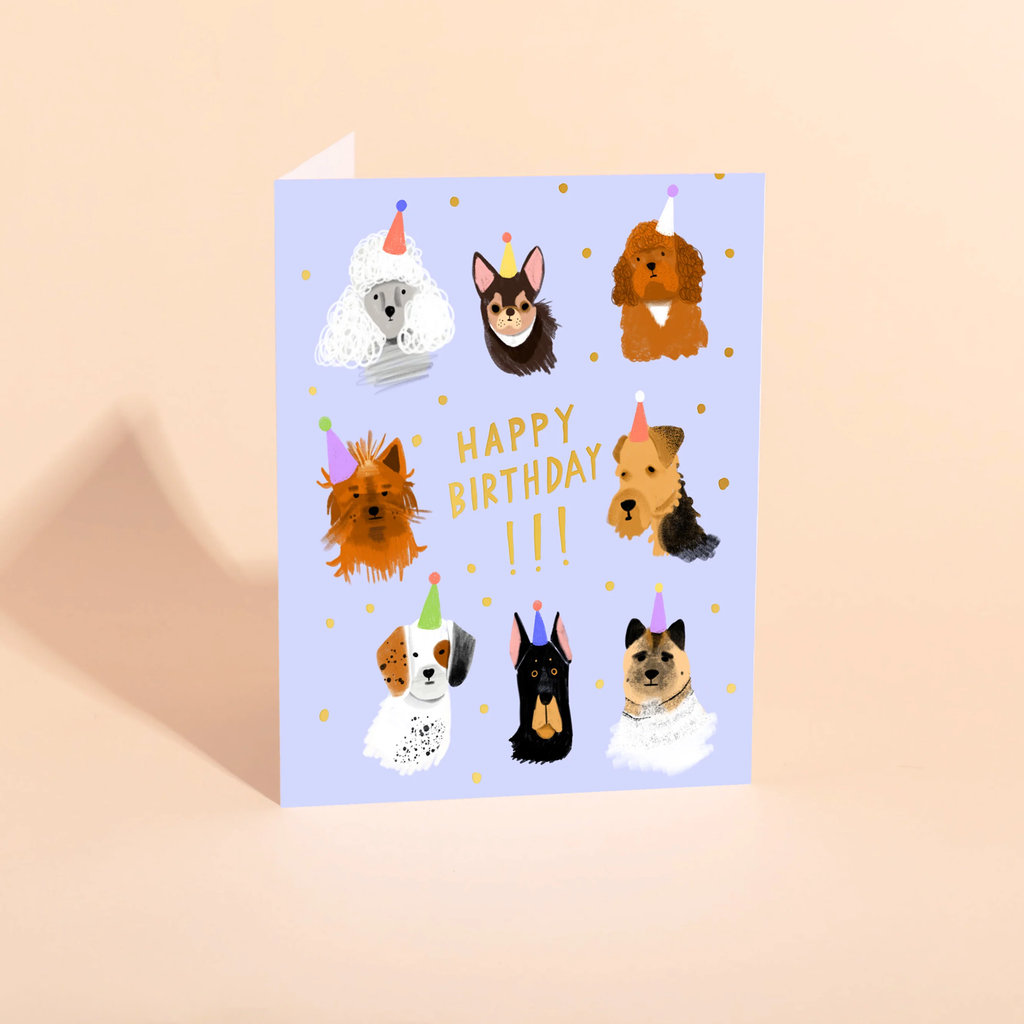 Birthday card with illustrations of dogs wearing party hats on a light purple background.canine crew carolyn suzuki