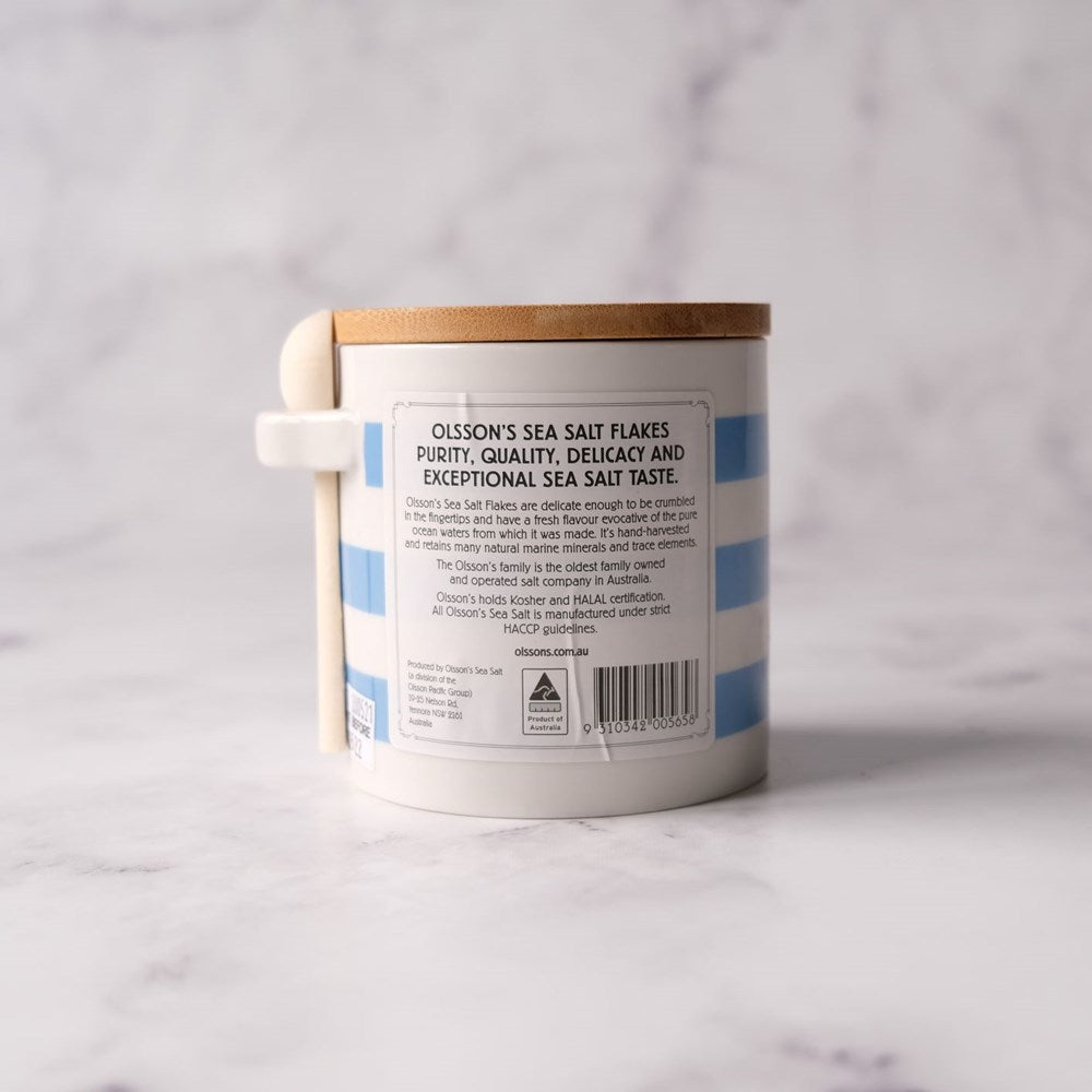 Container of Olsson's Sea Salt Flakes with label on a light gray background