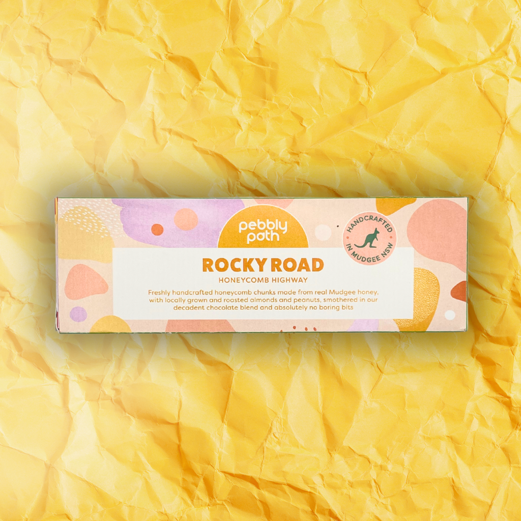 Pebble Path Rocky Road honeycomb highway packaging on a yellow textured background